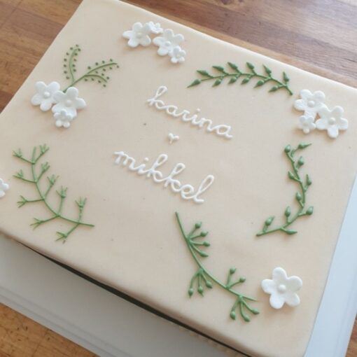 Enkel kage med parrets navne, hvide blomster og grønt i sprøjte glasur